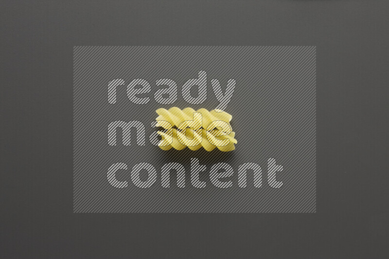 Fusilli pasta on grey background