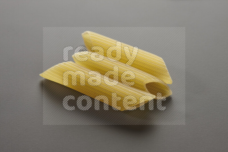 Penne pasta on grey background