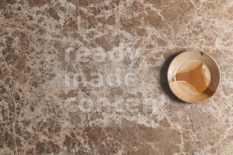 صحن فخاري متعدد الألوان على خلفية من الرخام البيج