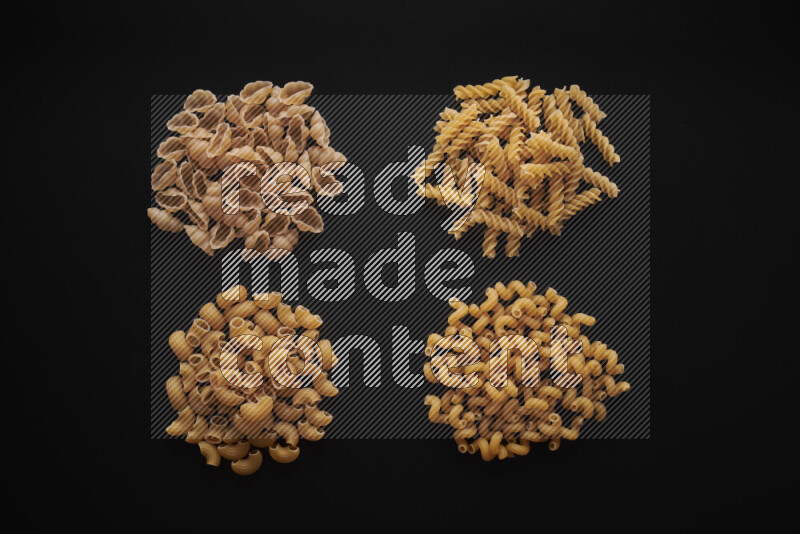 Different pasta types in bunches on black background