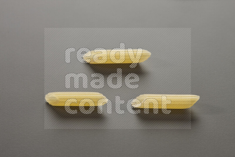 Mini penne pasta on grey background