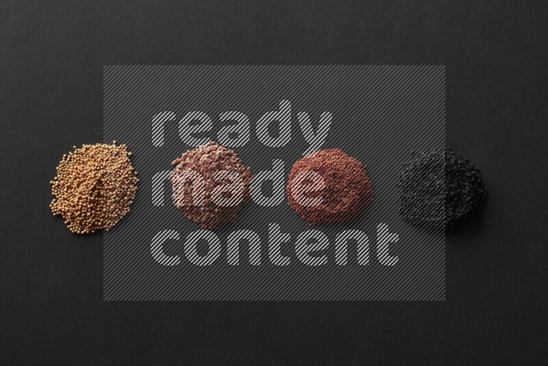Black seeds, mustard seeds, garden cress and flax on a Black background