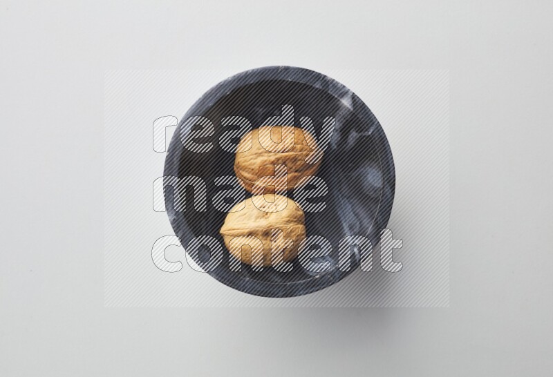 Top-view shot of walnut in a container on white background