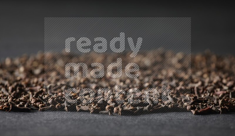 Cloves spread on black flooring