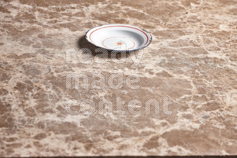 A vintage metal plate on beige marble background