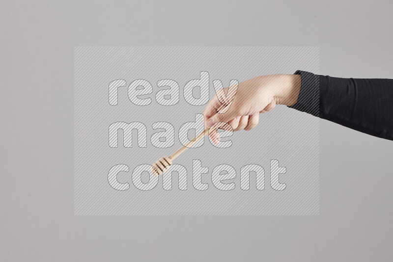 A woman in black abaya holding different wooden essentials in different positions