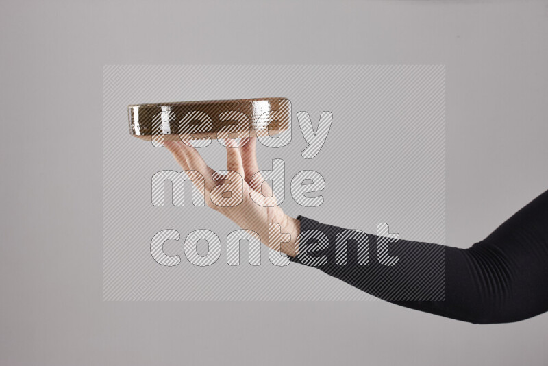 A woman in black abaya holding different pottery essentials in different positions