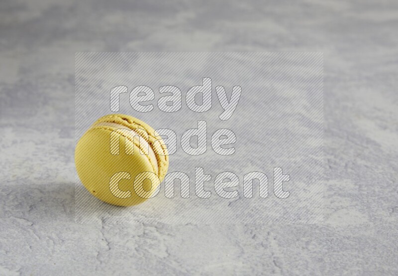 45º Shot of Yellow Lime macaron on white marble
