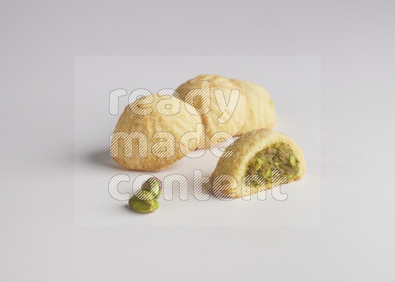 Four Pieces of Maamoul filled with pistachio  paste one of them is cut direct on white background