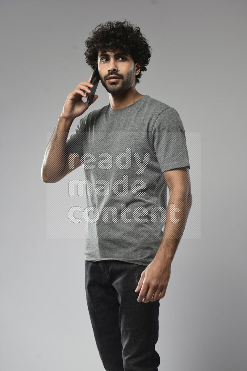 A man wearing casual standing and talking on the phone on white background