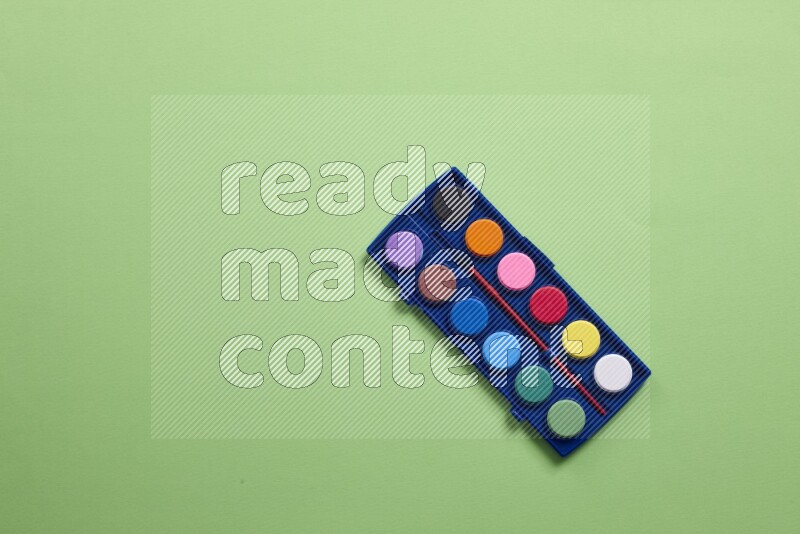 Watercolor paint set on green background