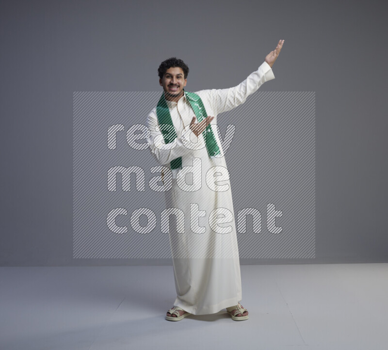 رجل سعودي يرتدي ثوب ابيض و شال يتفاعل مع الكاميرا