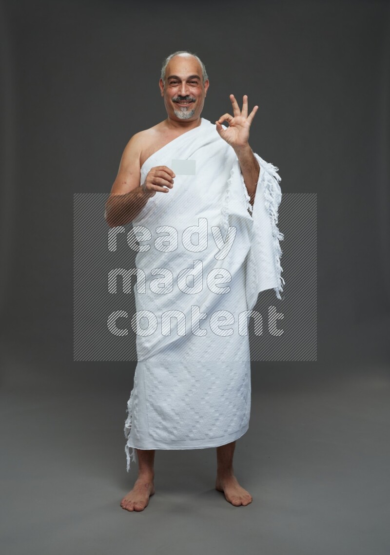 A man wearing Ehram Standing holding ATM card on gray background