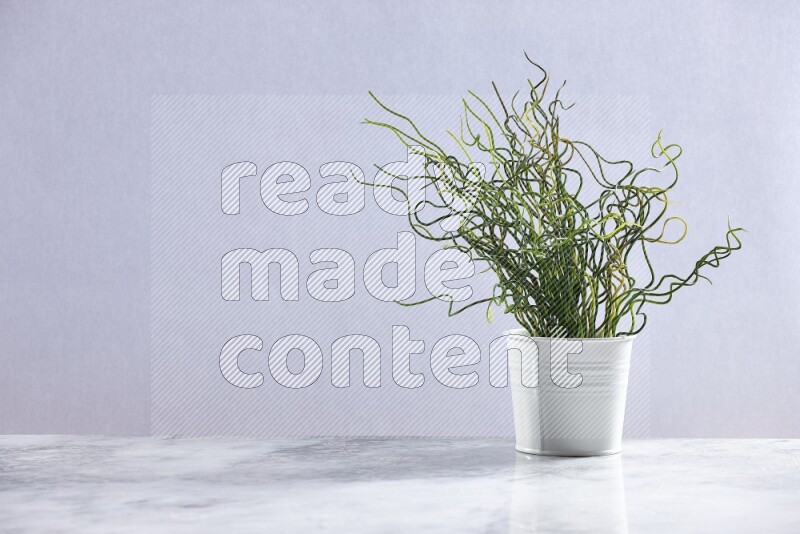Green artificial plant in white pot on grey marble background