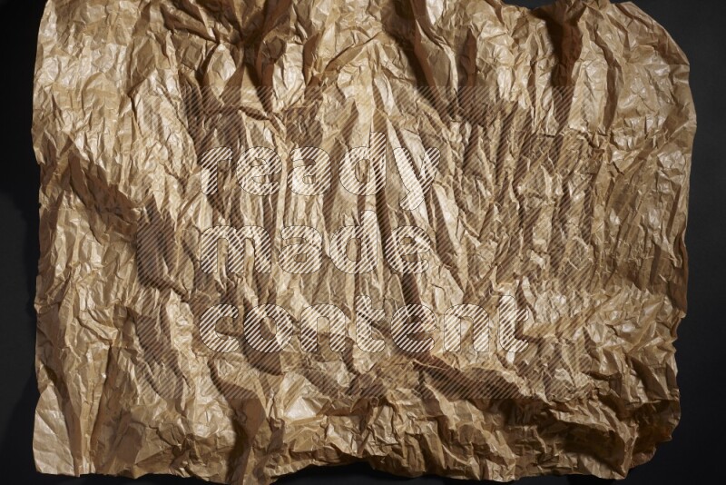 Crumpled craft paper on black background