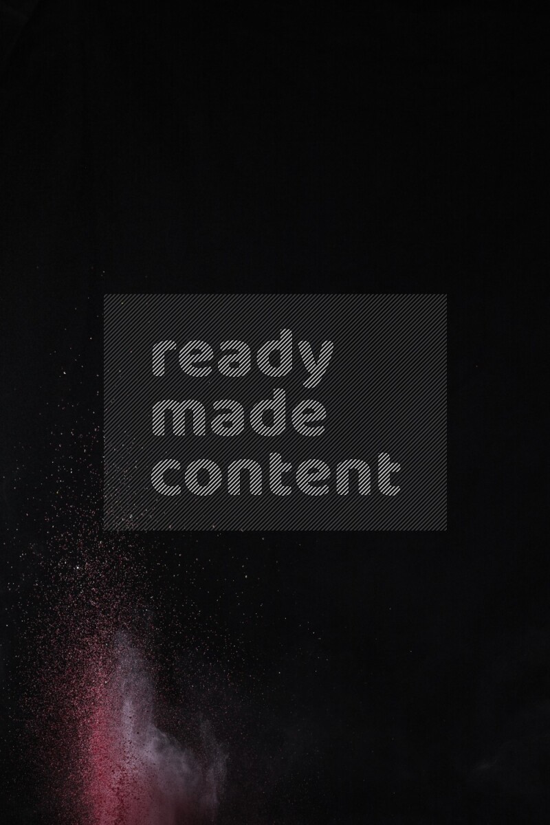 A side view of red powder explosion on black background