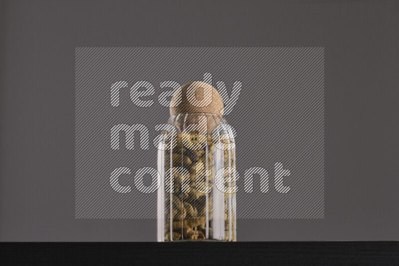 Turmeric in a glass jar on black background