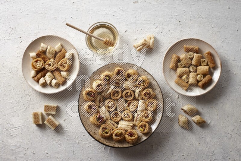 Oriental sweets in pottery plates with honey in a light setup