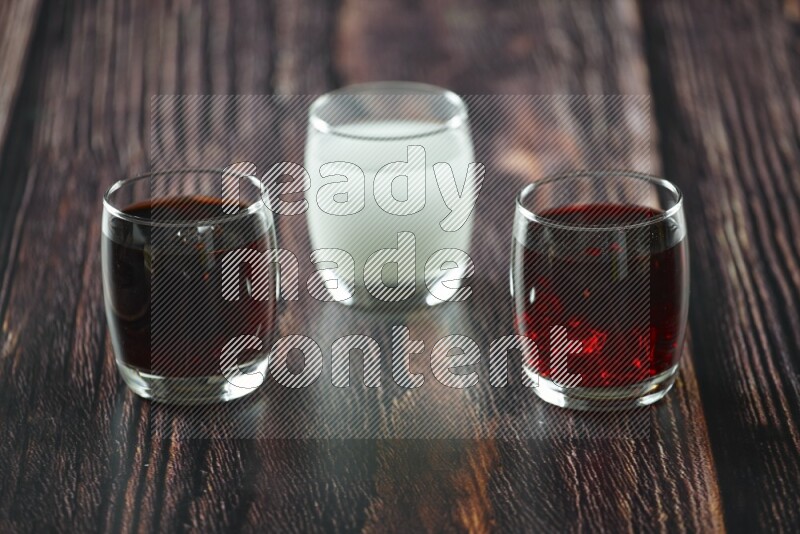 Cold drinks in a glass cup such as water, tamarind, qamar eldin, sobia, milk and hibiscus on wooden background
