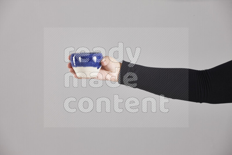 امرأة ترتدي عباءة سوداء تحمل أدوات فخارية مختلفة في أوضاع متعددة