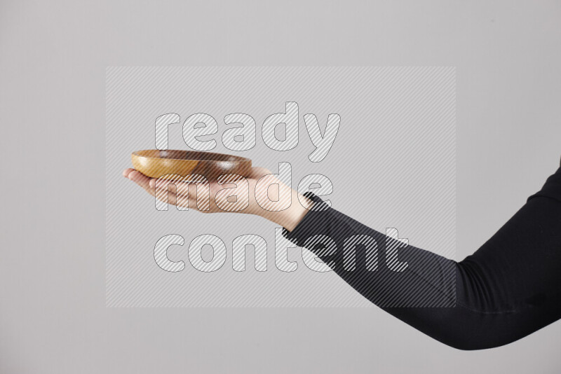 A woman in black abaya holding different wooden essentials in different positions