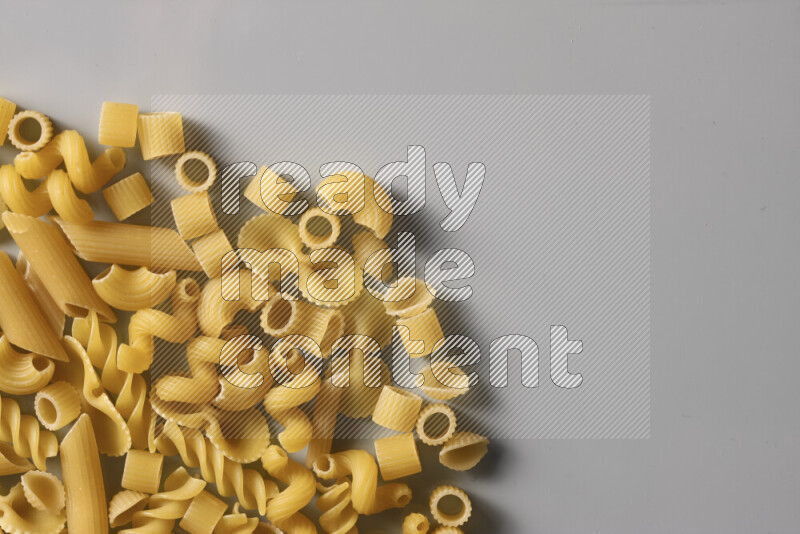 Different pasta types on light blue background