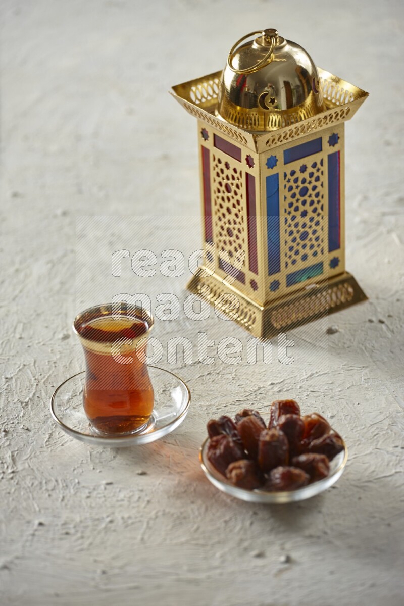 A golden lantern with different drinks, dates, nuts, prayer beads and quran on textured white background