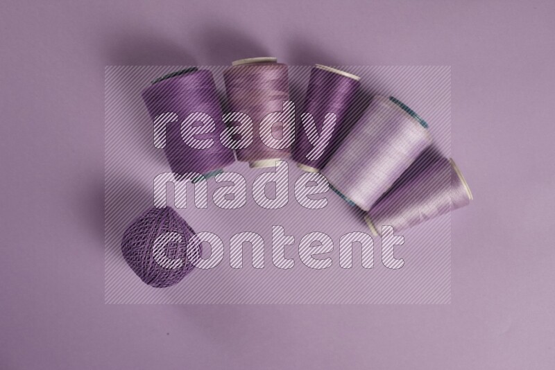 A purple collection of sewing and tailoring tools arranged on a purple background