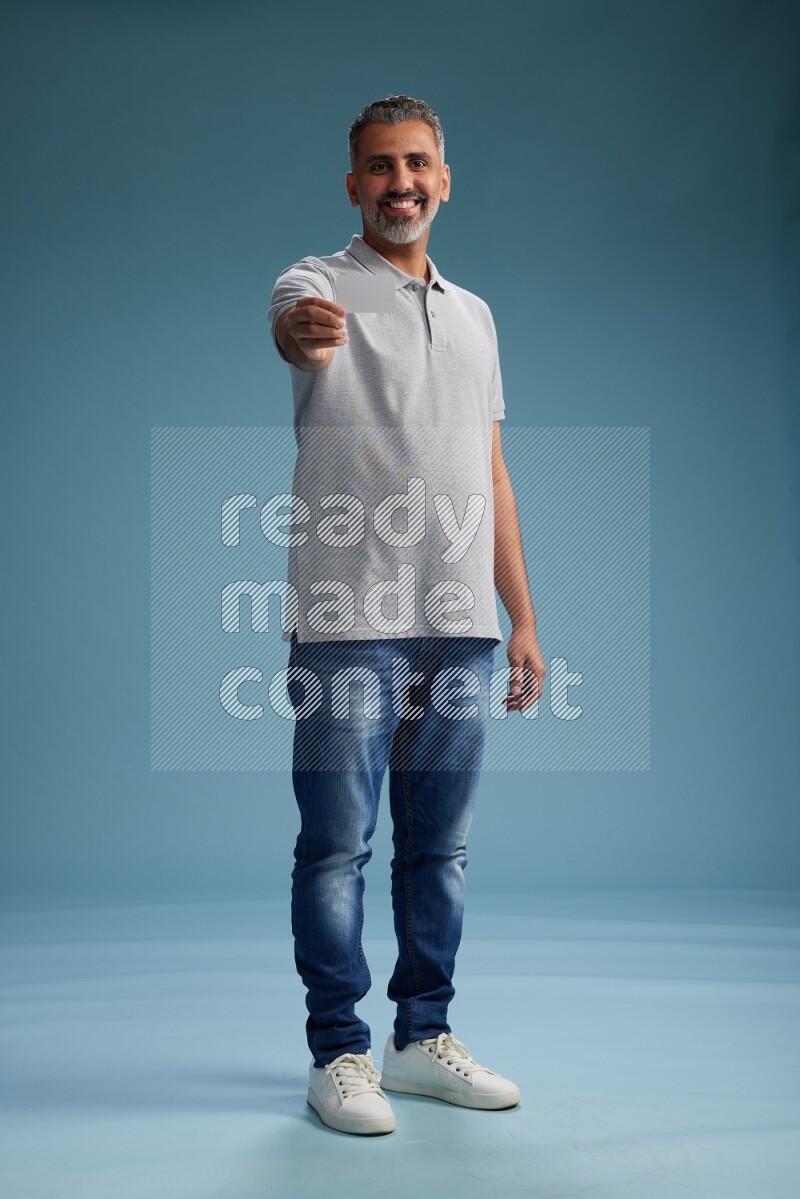 Man Standing holding ATM on blue background