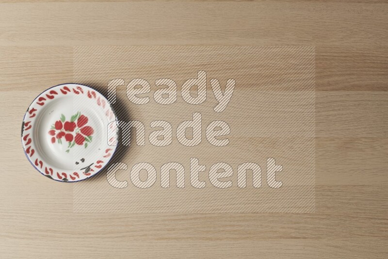 A vintage metal plate on light wooden background