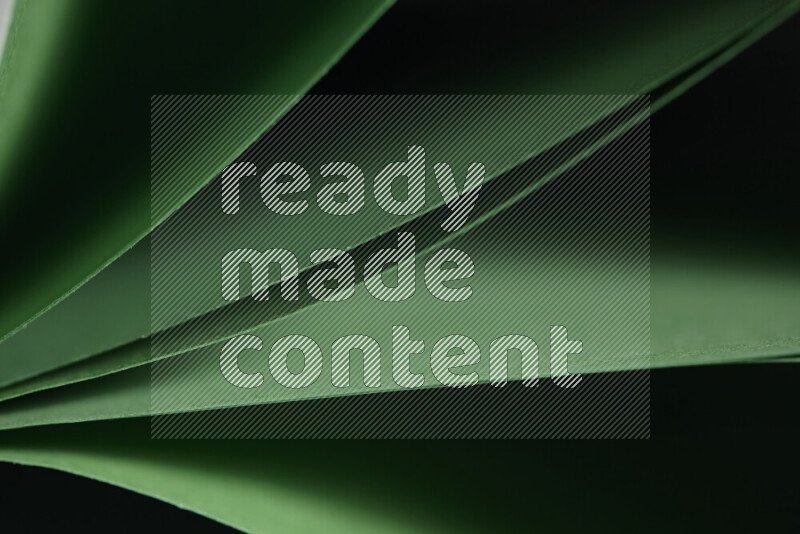 An abstract art showing green paper sheets arranged in an overlapping curves