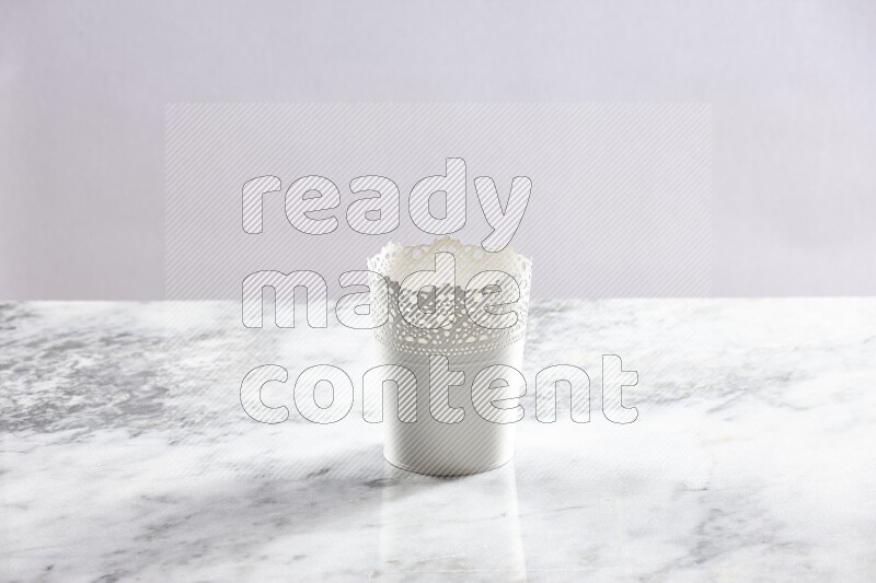 An empty white plant pot on grey marble background