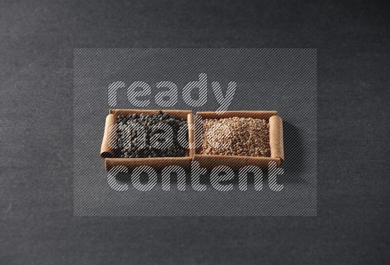 2 squares of cinnamon sticks full of mustard seeds and black peppers on black flooring