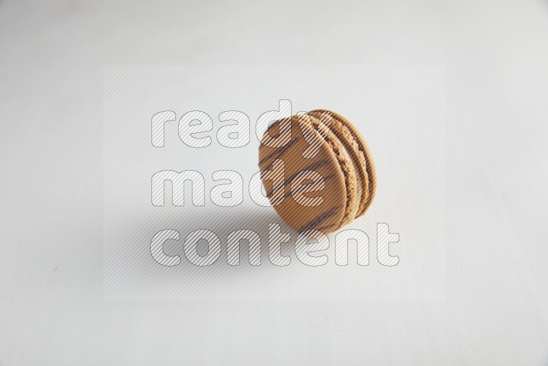 45º Shot of light brown  Almond Cream macaron on white background