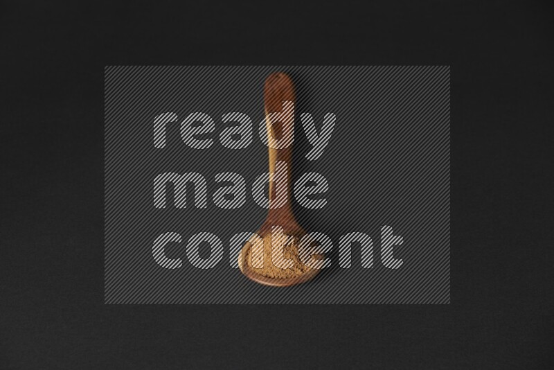 بودرة القرفة في مغرفة خشبية