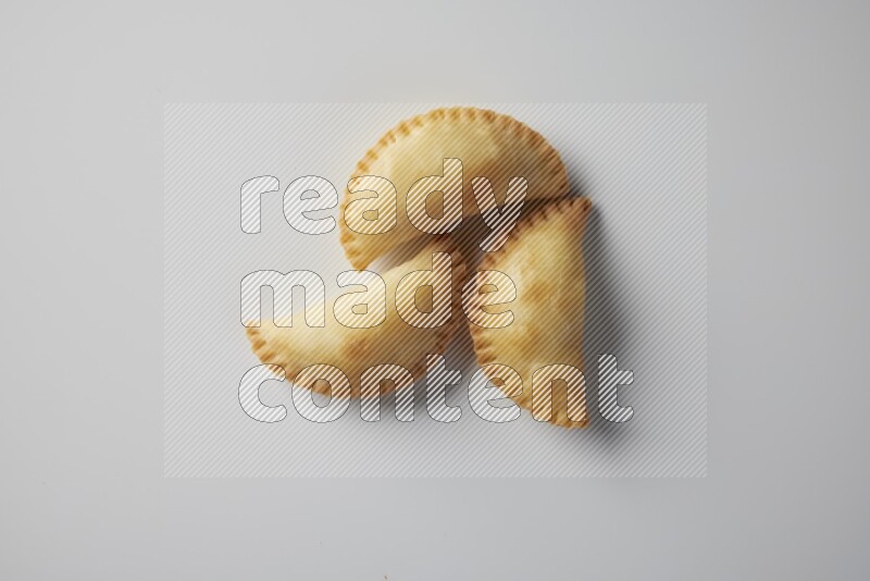 Three fried sambosa from a top angle on a white background