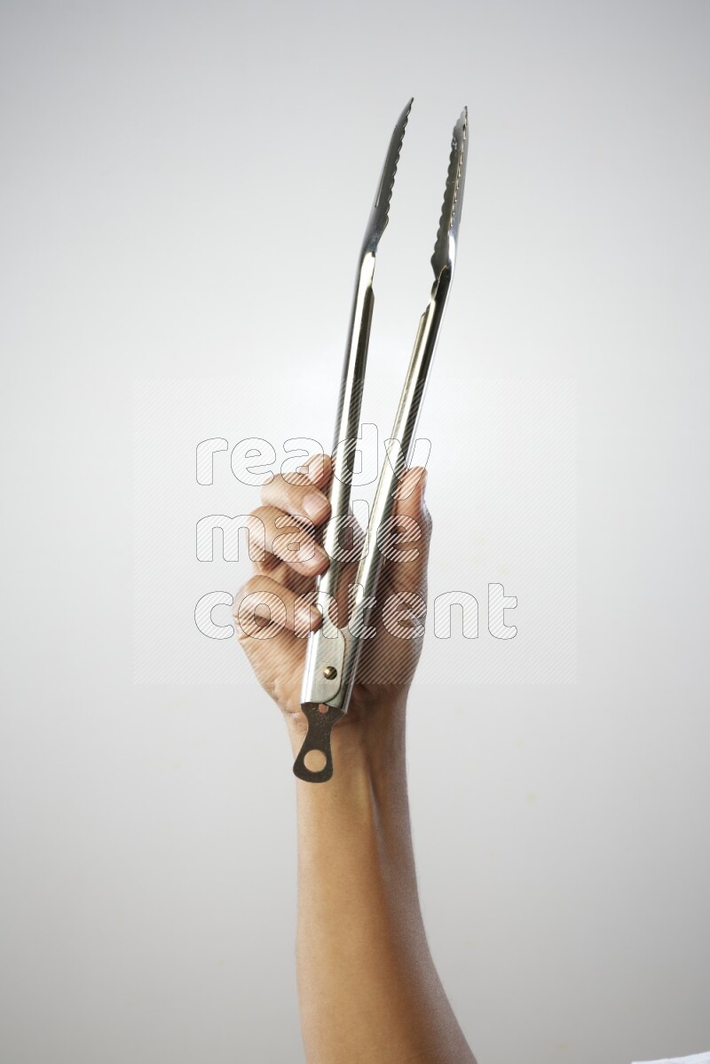 Male Hand Holding Tongs on white background