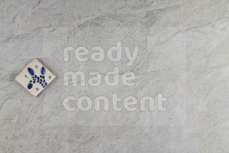 A decorative pottery coaster on grey marble background