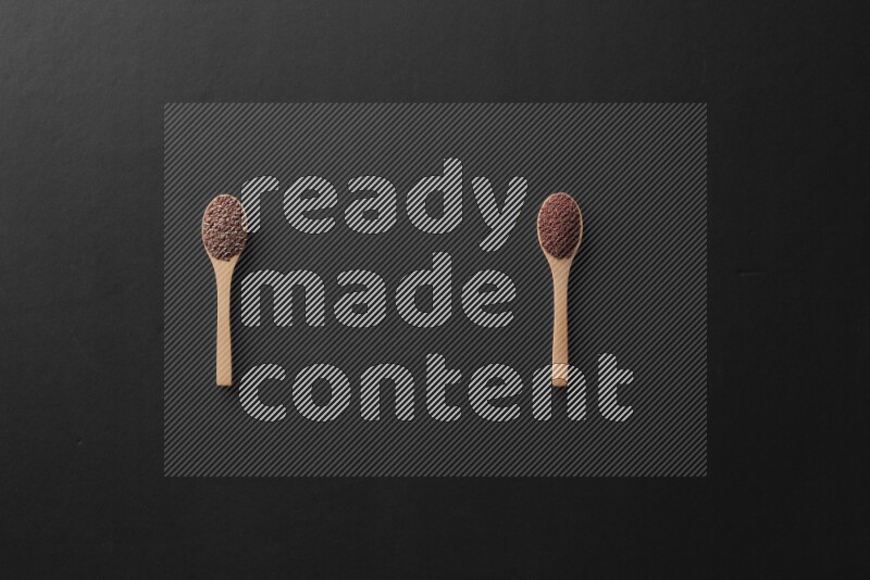 wooden spoons filled with white peppers, mustard seeds, black seeds, garden cress, cumin and flax on black flooring