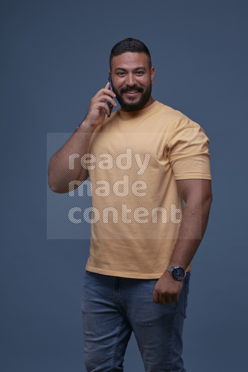 A man Calling on Blue Background wearing Orange T-shirt