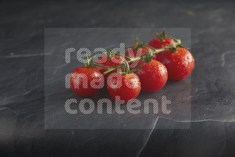 Red cherry tomato vein on a textured black slate background 45 degree