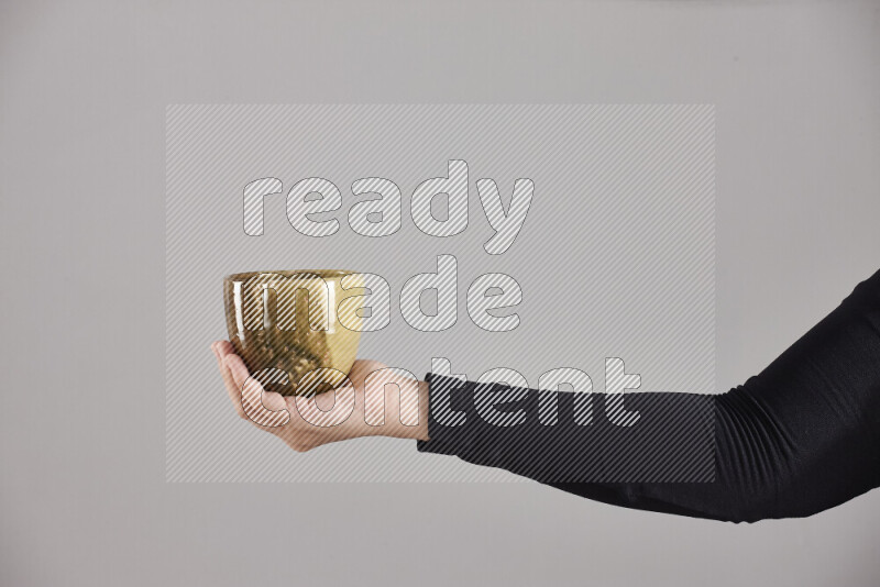 A woman in black abaya holding different pottery essentials in different positions