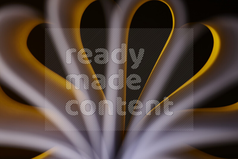 An abstract art piece displaying smooth curves in white and yellow gradients created by colored light