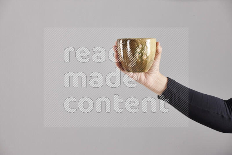 A woman in black abaya holding different pottery essentials in different positions