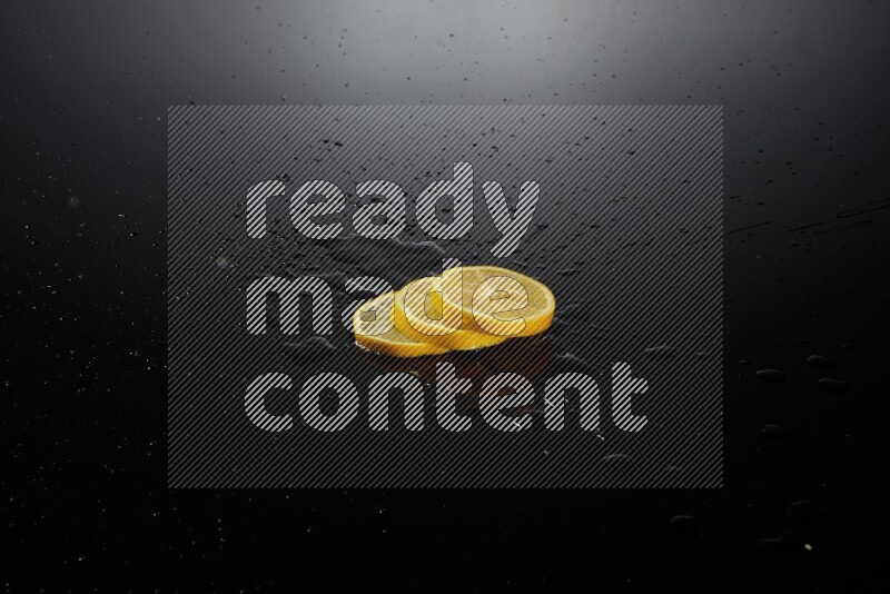 Lemon slices with water drops, and droplets on black background