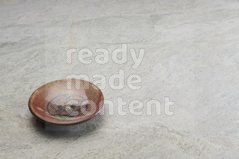 A decorative pottery plate on grey marble background