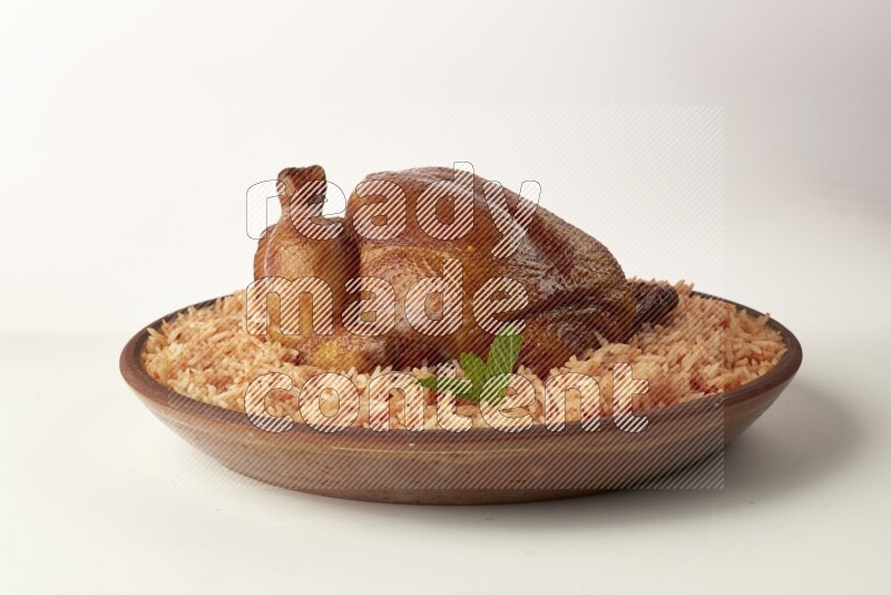 red basmati Rice with whole roasted chicken on a pottery plate direct on white background