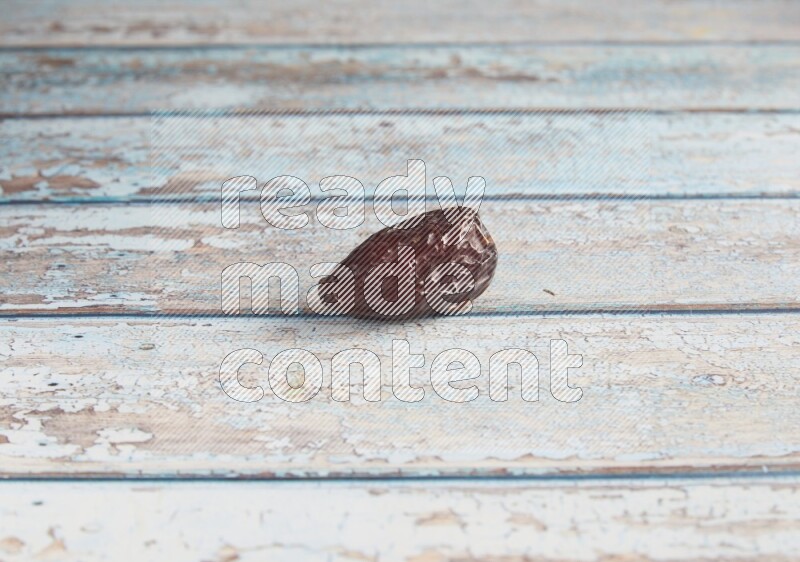 one madjoul date on a light blue wooden background