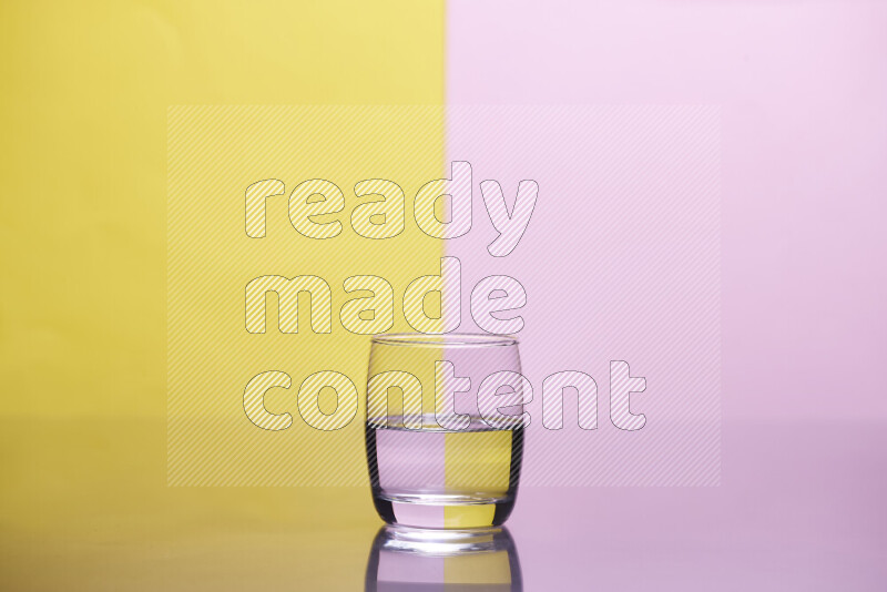 The image features a clear glassware filled with water, set against yellow and rose background