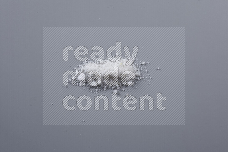 Bunches of table salt, coarse sea salt, fine himalayan salt and coarse himalayan salt on grey background